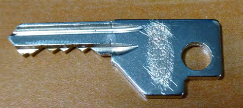Fig. 1: A key with an engraved serial number scratched off (top); Fig. 2: Forescatter Diode (FSD, upper) and Secondary Electron (SE, lower) images showing only a partially visible letter "O" in the serial number using traditional SEM techniques